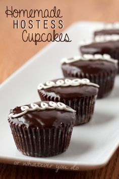 four chocolate cupcakes on a white plate