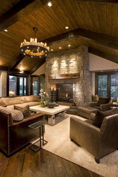 a living room filled with lots of furniture and a fire place in the middle of it