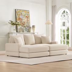 a living room with a white couch and rugs on the floor in front of a large window