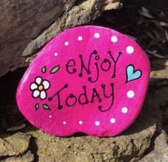 a rock with the words enjoy today painted on it