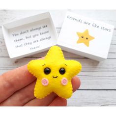 a hand holding a small yellow star in front of a white box with words on it