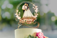 a wedding cake topper with a bride and groom on it, surrounded by flowers