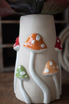 a ceramic planter with mushrooms painted on it