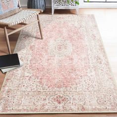 an area rug in a living room next to a chair and potted plant on the floor