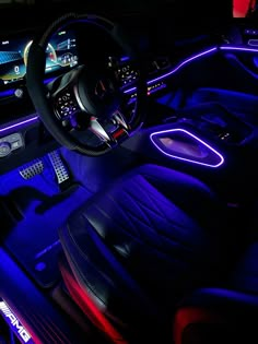 the interior of a car is lit up with blue and red lights, including an illuminated steering wheel