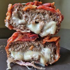 two meatloaf sandwiches stacked on top of each other with cheese and tomato toppings