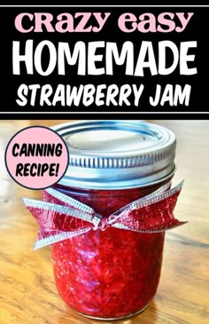 a jar filled with homemade strawberry jam sitting on top of a wooden table next to a sign