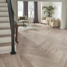 a living room filled with lots of furniture and a staircase leading up to the second floor