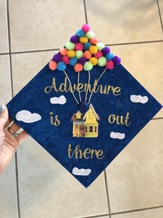 a blue graduation cap with the words adventure is out there on it