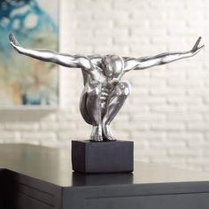 a silver statue sitting on top of a wooden table