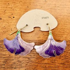 This graceful, Art Nouveau inspired design shows a gingko leaf in dramatic shades of purple. Handcrafted of 24k gold over sterling silver. The enameled earrings have french backs for pierced ears. Size: 1 1/4 inches.The Shashi earrings offered here are vintage stock from the 1970's and 1980's. They were designed by the Shashi Singapuri, crafted by hand, and were part of a line featured on the cover of vogue (quite a handful of times) and numerous other fashion magazines. Iris Earrings, Petals Falling, Enameled Earrings, Cloisonne Earrings, Art Nouveau Earring, Gingko Leaves, Blue Dangle Earrings, Laurel Burch, Jewelry Techniques