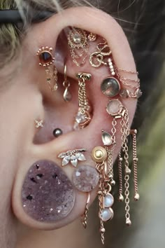 a close up of a person's ear with different types of jewelry on it