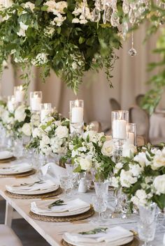 the table is set with white flowers and candles