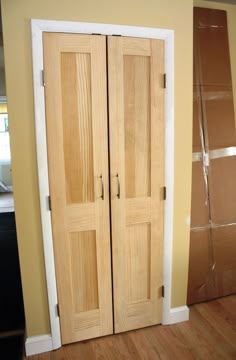 two wooden doors sitting next to each other on a hard wood floor in a room