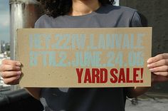 a woman holding up a yard sale sign