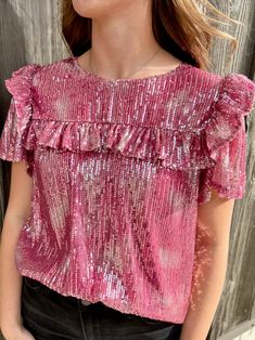 Life's a party and you'll be center stage in this sassy sequin top! Whether you choose vibrant pink or subtle taupe, you'll be ready to dance the night away with its short sleeves and flirty ruffle detail. Get the life of the party look in this fun top! 95% Polyester 5R% Elastane Festive Pink Sequin Tops, V-neck Sequin Tank Top For Spring, Pink Sequined Short Sleeve T-shirt, Metallic Shimmer V-neck Top, Chic V-neck Sequin Tank Top, Center Stage, Party Tops, Sequin Top, Party Looks