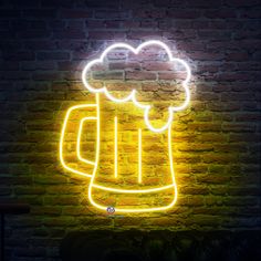 a neon beer sign is lit up against a brick wall in the shape of a mug