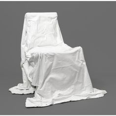 a chair covered in white cloth sitting on top of a gray floor