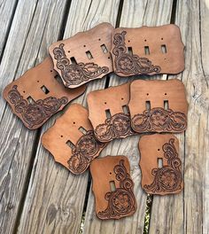 six pieces of brown leather sitting on top of a wooden table