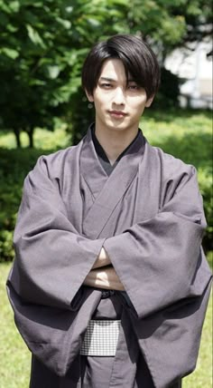 a young man dressed in traditional japanese garb and holding his hands on his hips