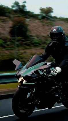 a man riding on the back of a motorcycle down a road