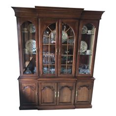 a wooden china cabinet with glass doors