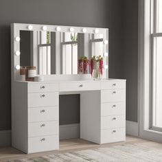 a white vanity with lights on it in front of a large window and a rug