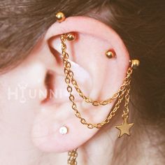 a close up of a person with ear piercings and chains on their backseats