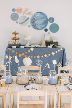 the table is set up for an outer space birthday party with blue and gold decorations