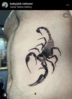 a scorpion tattoo on the side of a man's stomach, with black ink