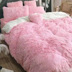 a fluffy pink bed with two pillows on it