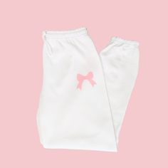 🛒Introducing the Pink Bow Soft Girl Era Sweatpants, the perfect mix of comfort and style! With an elastic waistband, these preppy sweats pants will keep you on-trend while still feeling cozy. Embrace the coquette trend with these trendy lounge pants. 📦FREE SHIPPING on orders $35 or more to US shoppers 👕Brand = Gildan 🧵Fabric = 50% Cotton / 50% Polyester ✂️Design = Blush Pink heat-applied vinyl 🎨Color = White -Colors will vary from computer to computer and monitor to monitor. -The colors shown may not be an exact representation. -Slight shade variations of garment colors are likely in the pigment dye process. 📏Sizing = Unisex -Please see size chart in photos -Sweatpants have more of an oversized fit -Drawstring elastic waistband, elastic cuffs and no pockets -Model is 5'0 and wearing Pink Cotton Sweatpants For Pajama Party, Cotton Sweatpants With Elastic Waistband For Sleepover, Cute Pink Cotton Pants, Cute Cotton Bottoms With Elastic Waistband, Cute Pink Pants With Elastic Waistband, Cute Cotton Pants With Elastic Waistband, Cute White Long Pants, Cute Bottoms With Elastic Waistband, Cute White Pants For Sleepover