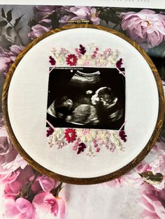 an embroidered photo frame with pink flowers surrounding it and a floral border around the picture