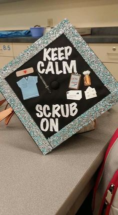 a cap that says keep calm and scrub on sitting on top of a table in a room