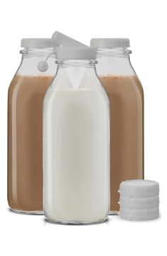 two glass jars filled with liquid next to a white container full of chocolate milk and a plastic cap