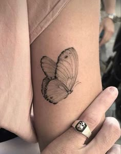 a woman's arm with a butterfly tattoo on the left side of her body