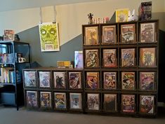 a room filled with lots of framed comics and books on top of a book shelf