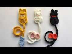 crocheted cat hair clips are lined up on a white surface, one is black and the other is yellow