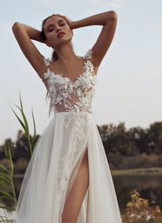 a woman in a white wedding dress posing with her hands on her head and legs behind her head