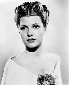 an old black and white photo of a woman with curlers in her hair wearing a dress