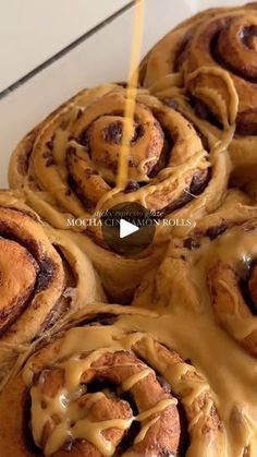 cinnamon rolls with icing sitting on top of a white plate