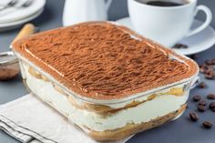 an ice cream sandwich with coffee beans on the table next to some cups and saucers