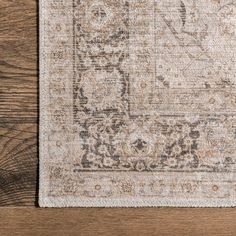 an area rug on a wooden floor with a brown and beige color scheme in the middle