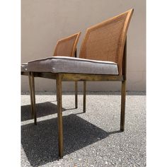 two wooden chairs sitting next to each other on top of gravel covered floored ground