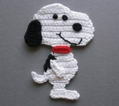 a crocheted dog with a red collar on it's neck sitting on top of a table