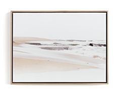 an abstract photograph of snow on the ground in front of a white wall with a wooden frame