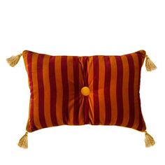 an orange and red striped pillow with tassels on the front, sitting against a white background