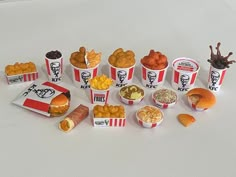 an assortment of food items displayed on white surface with black and red lettering, including hotdogs, macaroni and cheese