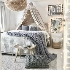 a bedroom with white walls and lights on the ceiling is decorated in shades of gray