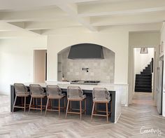 a kitchen with an island, stove and several chairs in front of the counter top